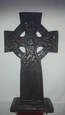 A celtic wooden cross made from dark cherry oak on a white background.